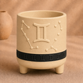 Warm beige Gemini zodiac planter with raised Gemini symbol, constellation, black zodiac band and footed base
