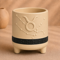 Warm beige Taurus zodiac planter with raised Taurus symbol, constellation, black zodiac band and footed base